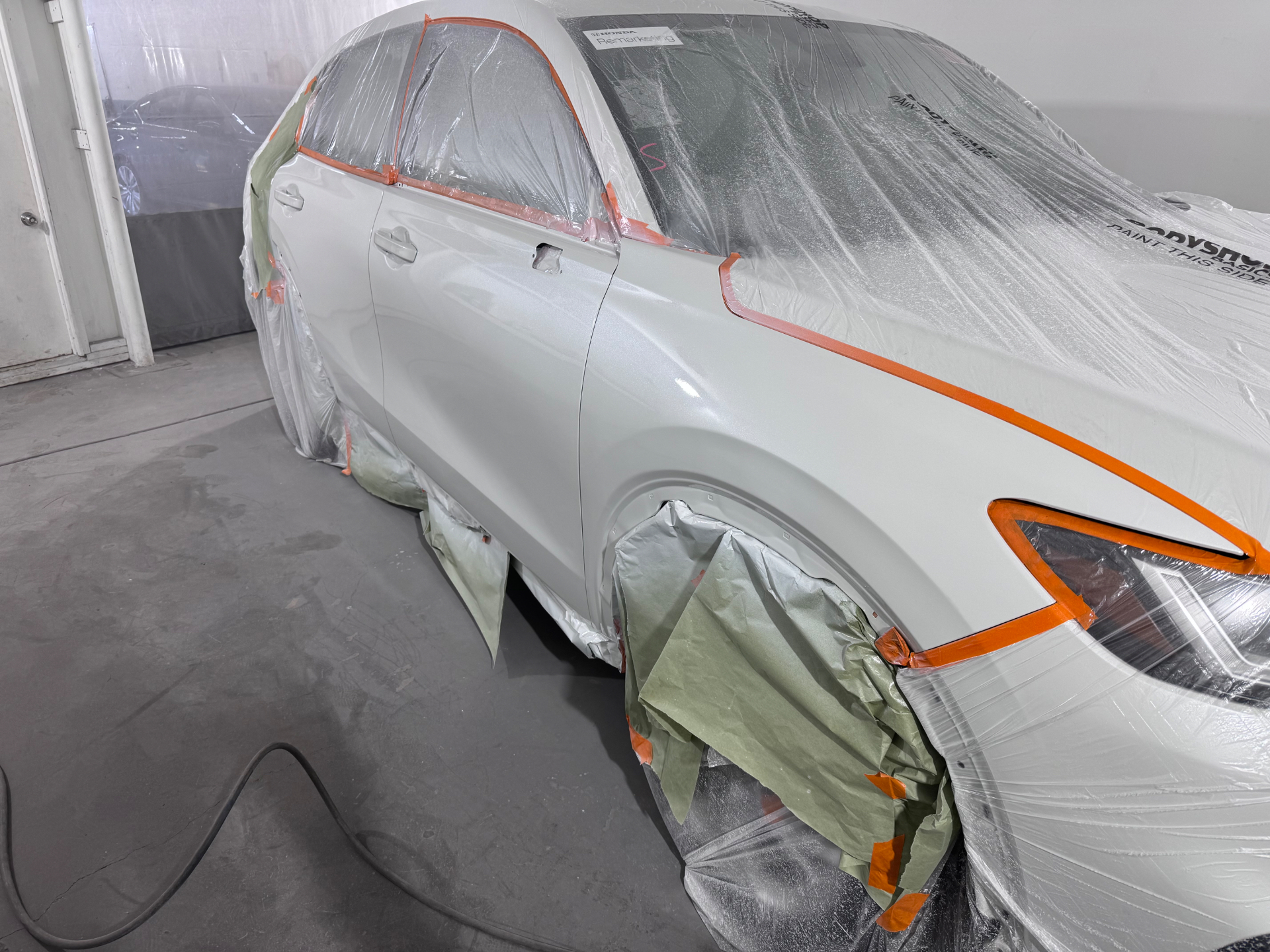 Customer viewing live photo of their vehicle being painted in the booth